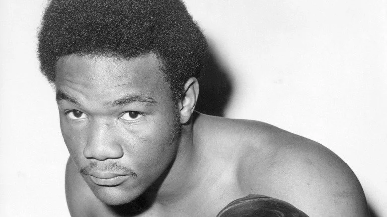 A young George Foreman posing in a boxing stance for a photo