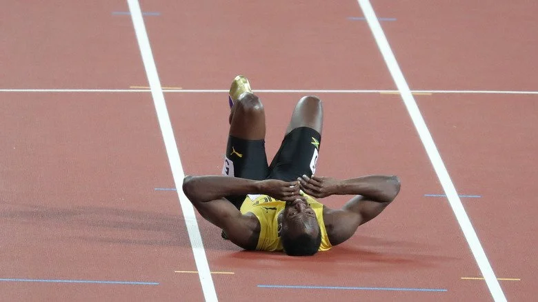 Usain Bolt allongé sur le sol