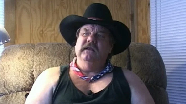 Blackjack Mulligan portant un chapeau de cowboy et parlant