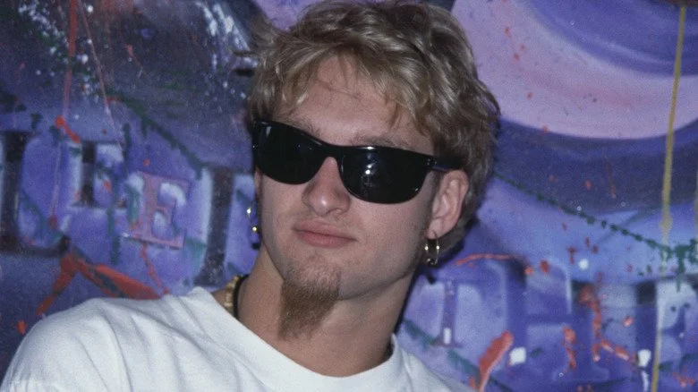 Layne Staley portant des lunettes de soleil et un t-shirt, regardant au loin