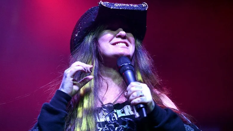 Rita Haney speaking on a mic at Dimebash