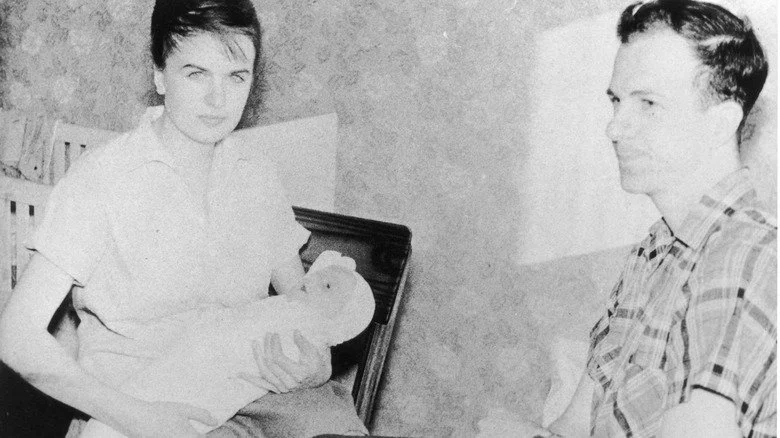 Lee Harvey Oswald assis avec sa femme et son bébé