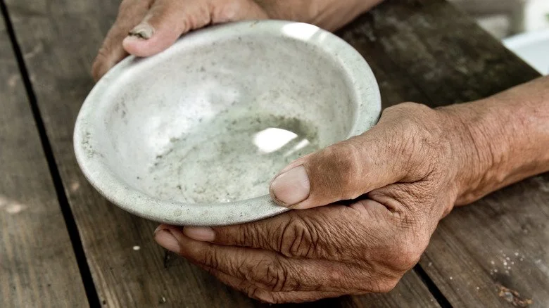 Homme pauvre tenant une assiette vide