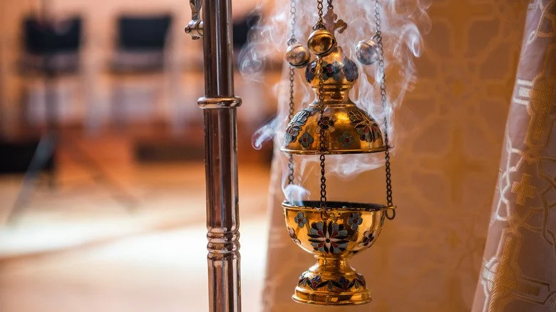 Encensoir orné fumant avec de l'encens