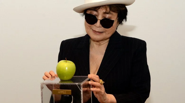 Yoko Ono avec une pomme sur un socle