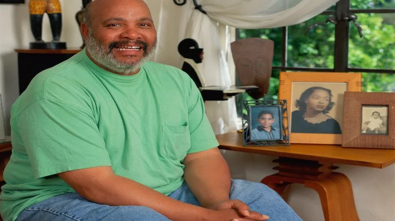 James Avery assis devant des photos de famille