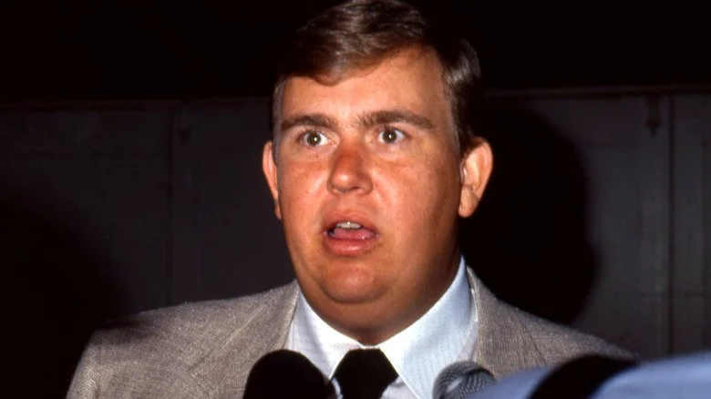 John Candy ouvrant la bouche devant un microphone