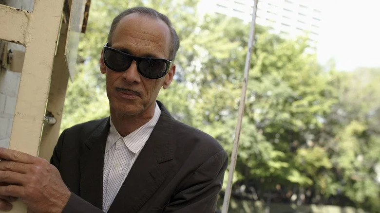 John Waters en lunettes de soleil