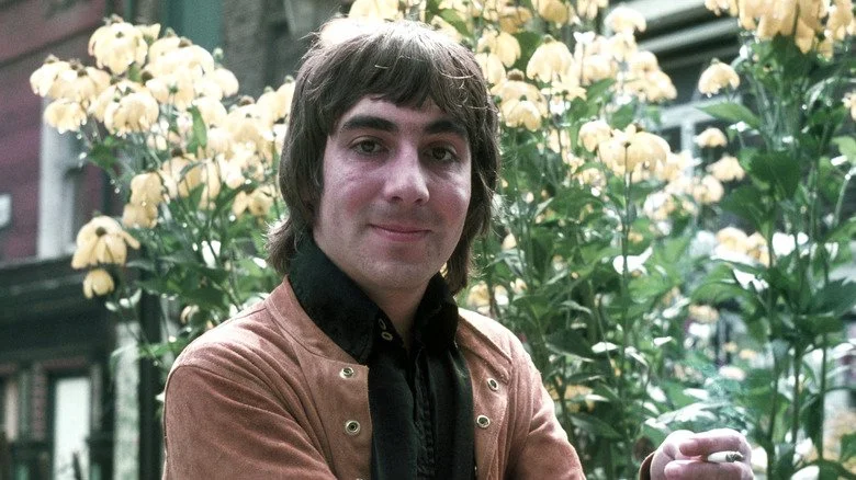 Keith Moon souriant devant des fleurs