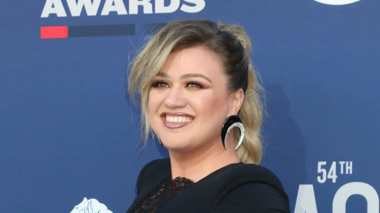 Kelly Clarkson souriante dans une robe noire