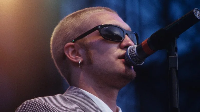 Layne Staley en profil, en costume chantant dans un microphone