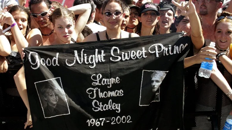 Fans tenant une bannière commémorative de Layne Staley lors d'un concert