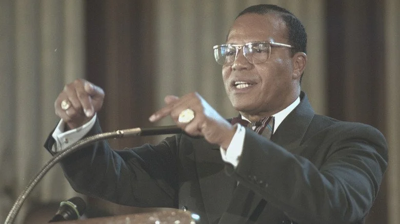 Louis Farrakhan pointing while speaking at a podium