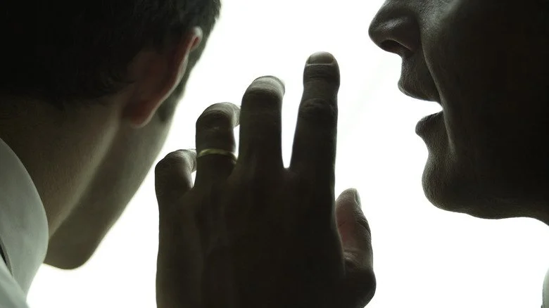 Homme confiant un secret à un autre