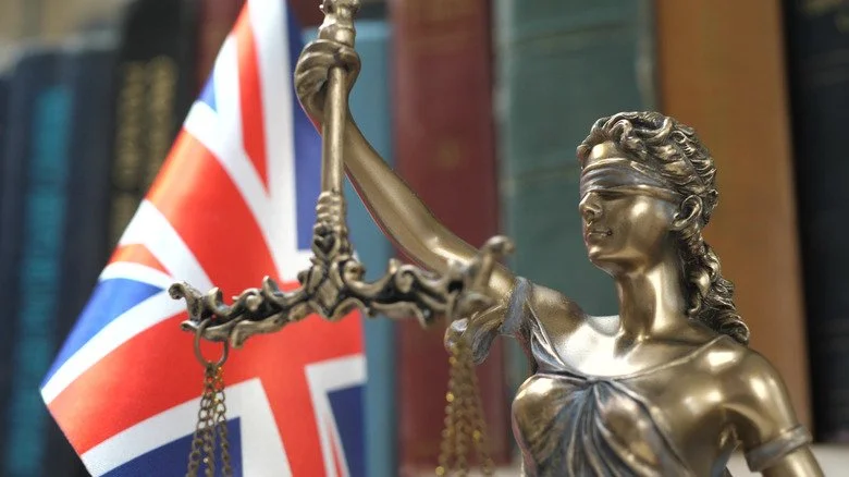 Statue de la Justice devant le drapeau britannique