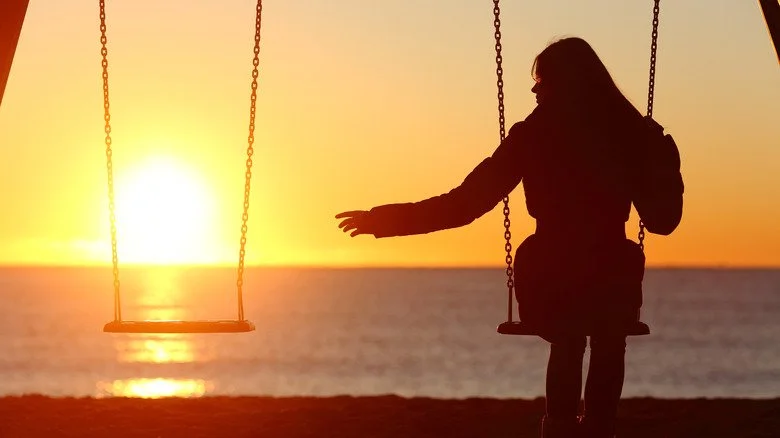 Femme qui atteint une balançoire vide