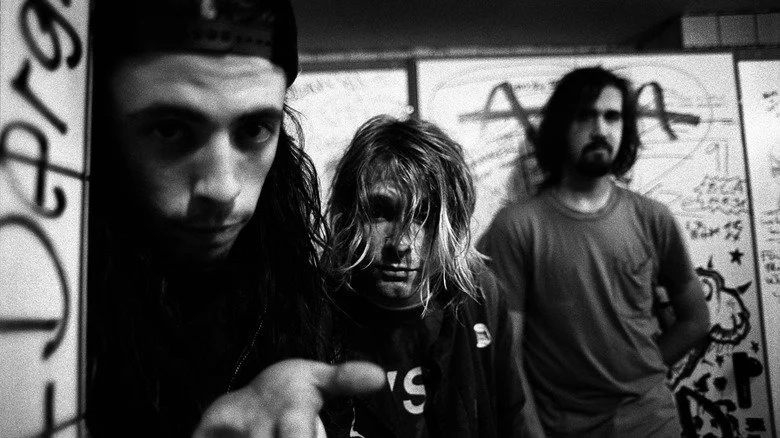 Nirvana's Dave Grohl, Kurt Cobain, and Krist Novoselic posing for a promotional photo in 1991