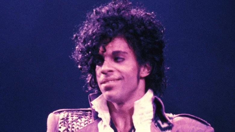 Prince souriant sur scène pendant la tournée Purple Rain