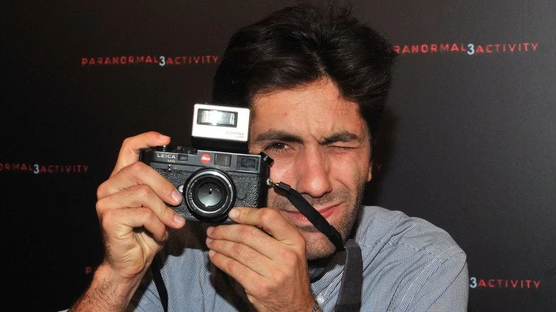 Nev Schulman prenant une photo avec une caméra