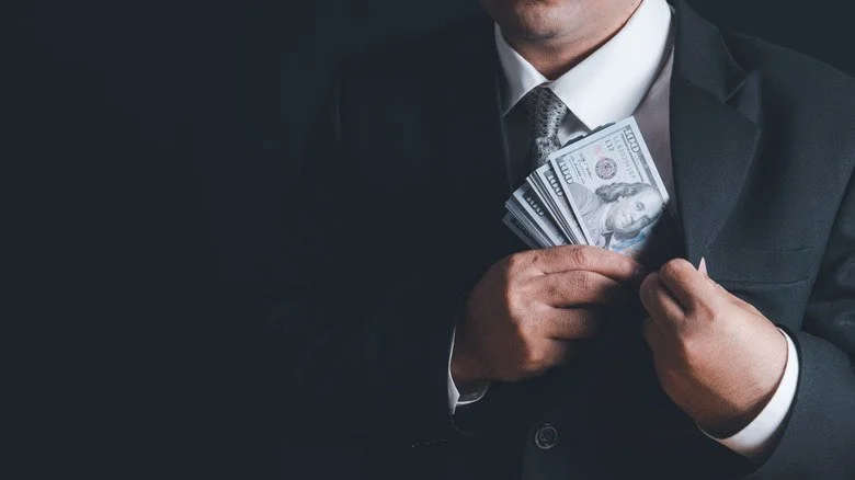 Homme prenant des billets de 100 dollars