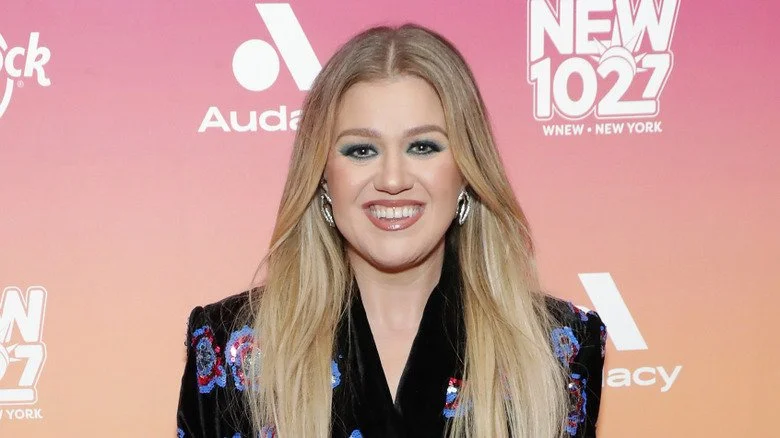 Kelly Clarkson souriante en chemise à fleurs lors d'un événement