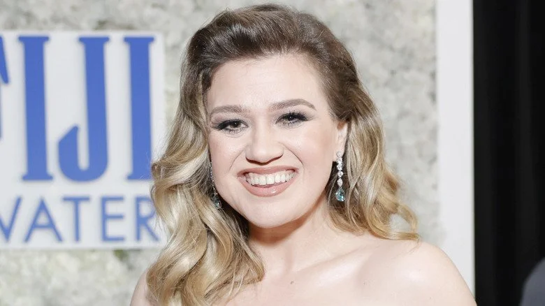Kelly Clarkson souriante en robe blanche lors d'un événement