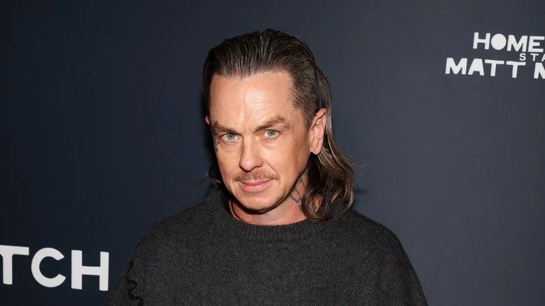 Sid Wilson avec les cheveux longs posant sur le tapis rouge