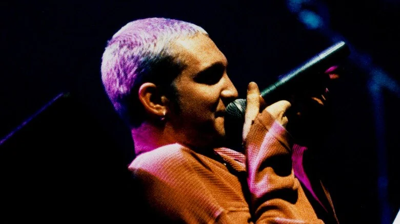 Layne Staley chantant en s'allongeant dans un pull orange