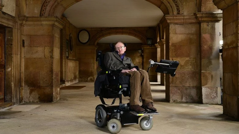 Stephen Hawking sous une arche en pierre à l'Université de Cambridge