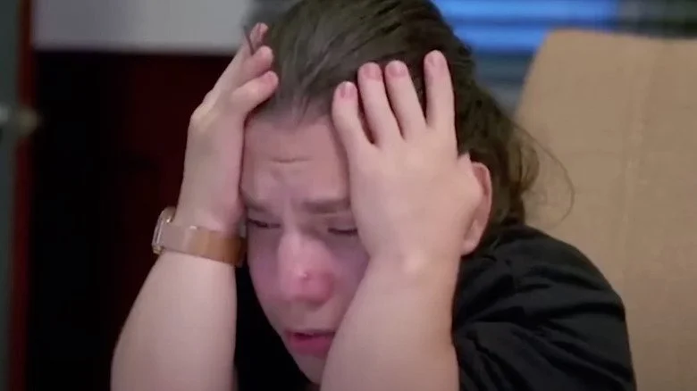 Natalia Grace pleurant, la tête dans les mains