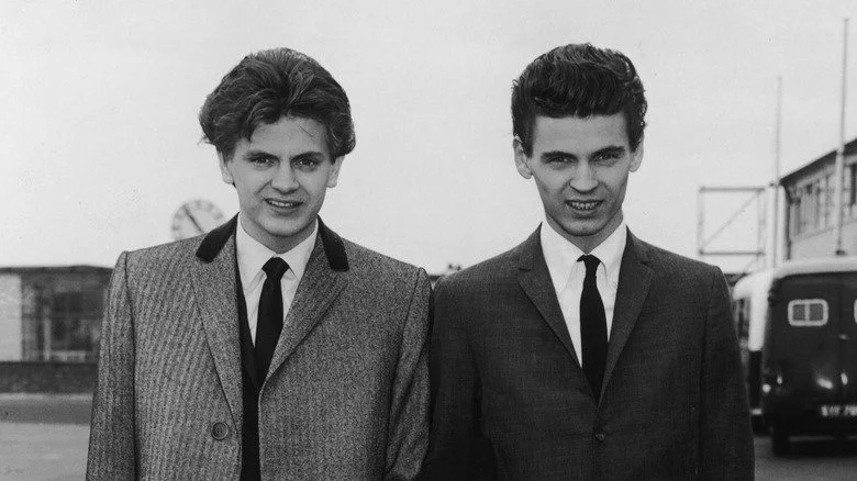 The Everly Brothers souriant en costumes noirs et blancs dans les années 1960