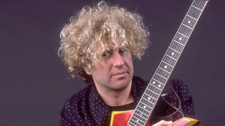 Sammy Hagar regardant avec scepticisme tout en tenant une guitare dans les années 80