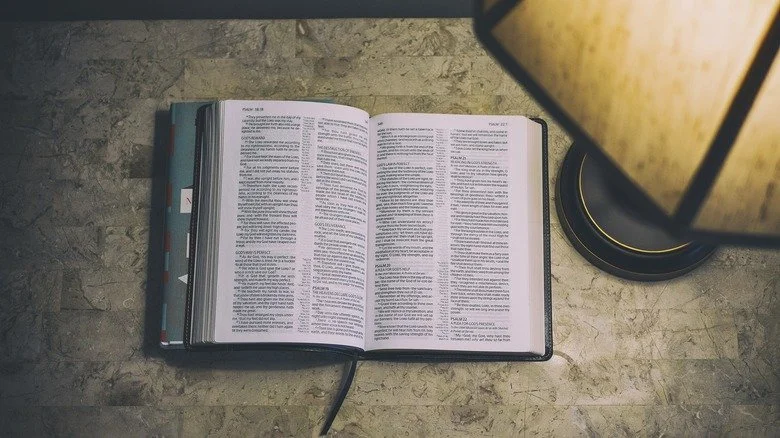 Bible ouverte sur une table avec une lampe