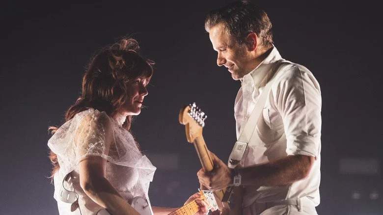 Jenny Lewis et Ben Gibbard en train de jouer de la guitare lors d'un concert de The Postal Service
