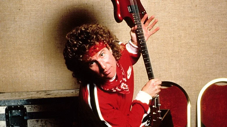 Sammy Hagar en rouge tenant une guitare rouge dans une photo de publicité des années 80