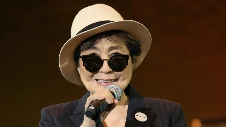 Yoko Ono souriant avec un micro