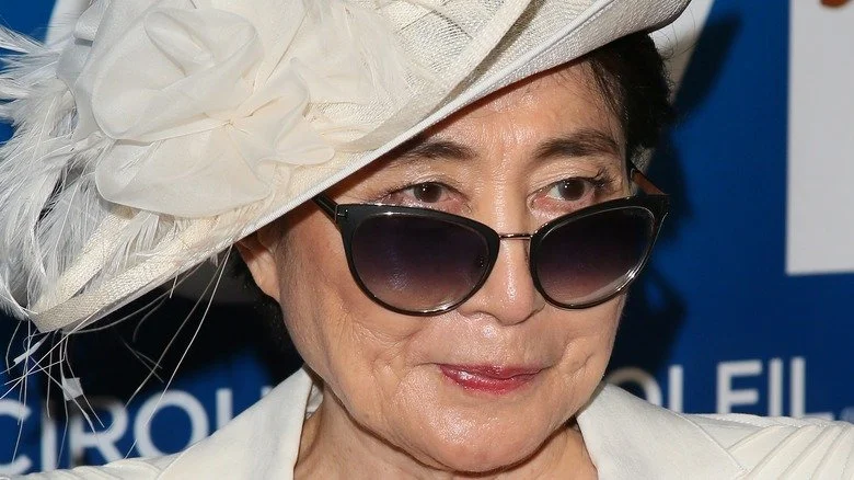 Yoko Ono en chapeau blanc et lunettes de soleil