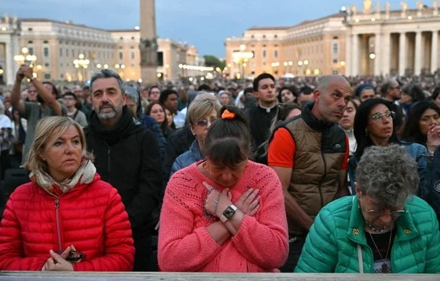 Des fidèles assistent à un chapelet en hommage au pape François après son décès, sur la place Saint-Pierre, au Vatican.