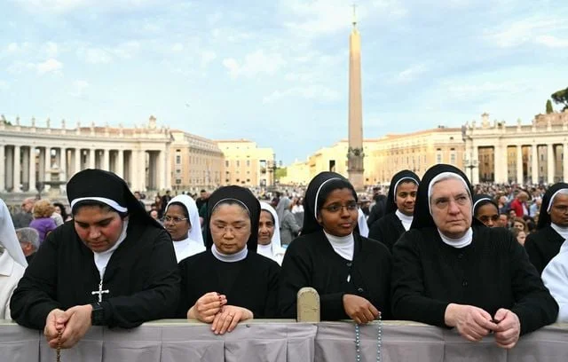 Des religieuses de différentes congrégations et des fidèles se rassemblent sur la place Saint-Pierre après le décès du pape François, au Vatican.