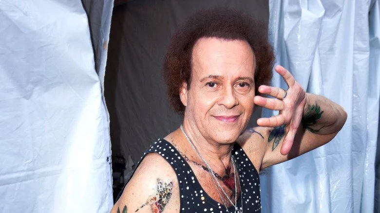 Richard Simmons se couvrant partiellement le visage avec la main