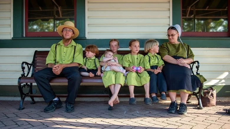 Famille amish assise sur un banc