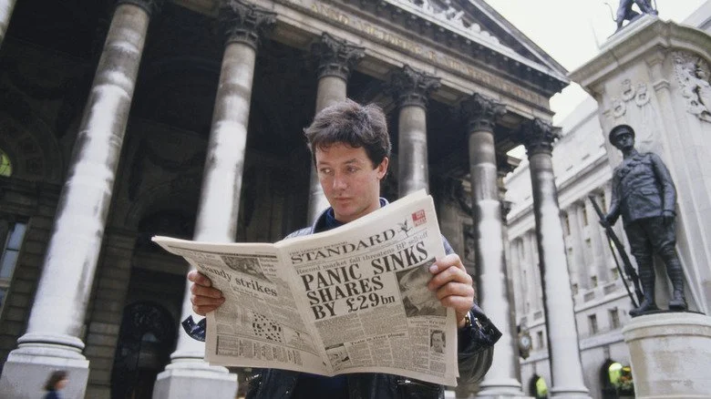 Un homme lit un journal sur le crash boursier de 1987