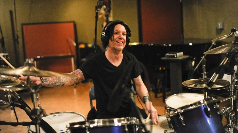 Chris Vrenna jouant de la batterie en studio tout en souriant
