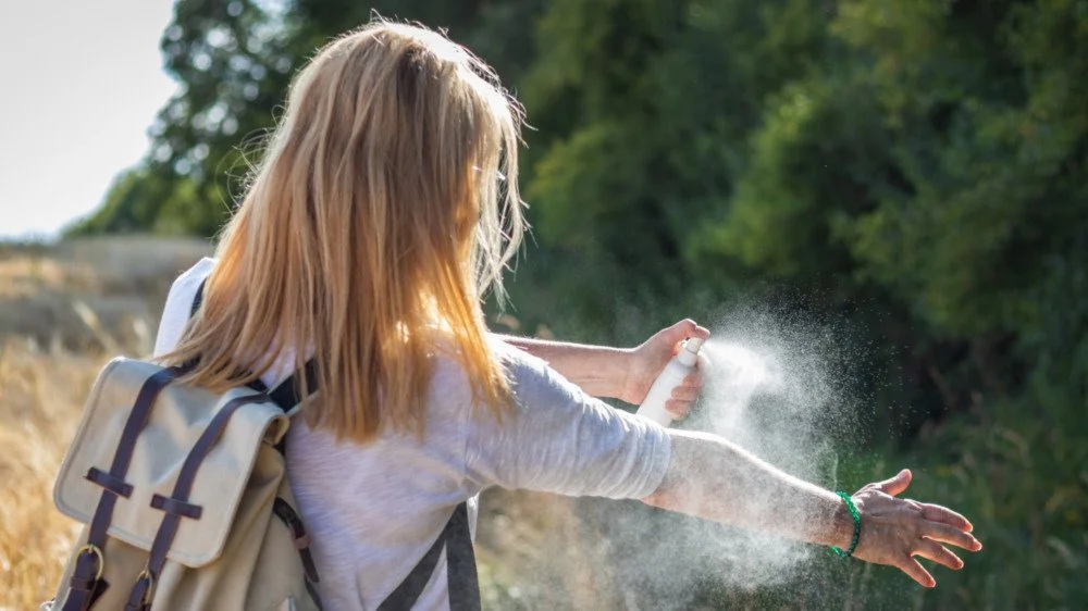 Femme applique un répulsif insectes