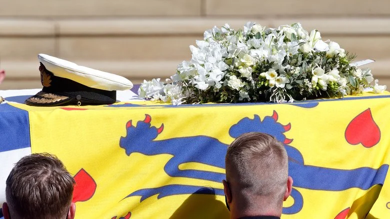 Prince Philip's coffin draped in his Royal Standard Flag and Royal Navy cap, sword and a bouquet