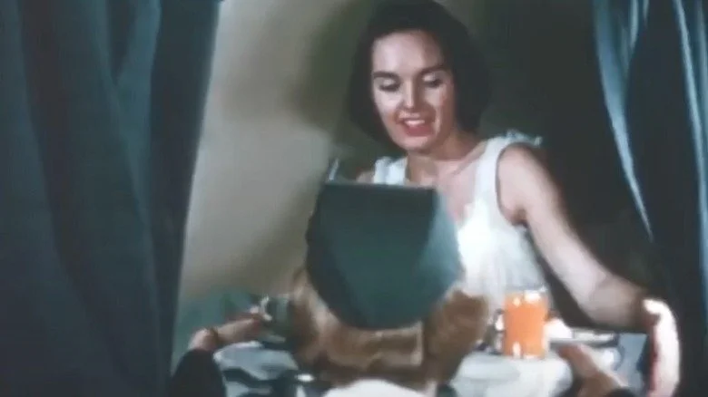 Un hôtesse de l'air servant le petit-déjeuner au lit