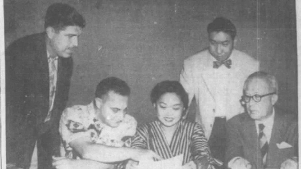 Patsy Mink assise, regardant un document