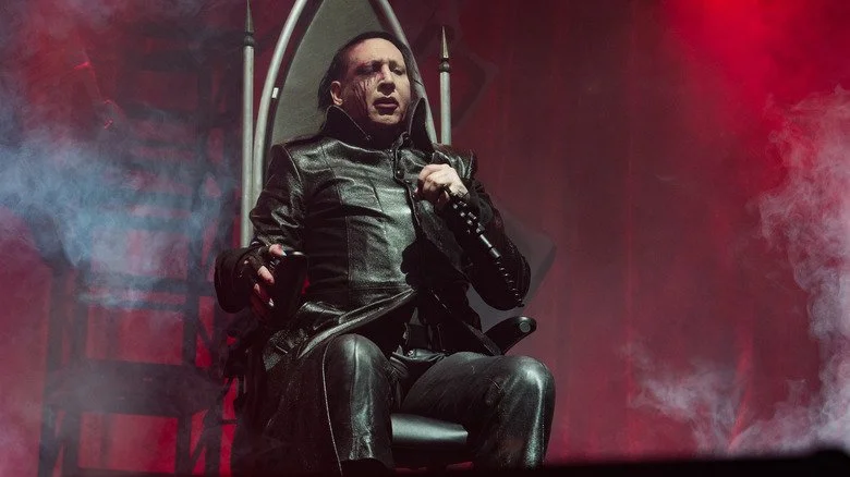Marilyn Manson assis sur un trône sur scène en 2017