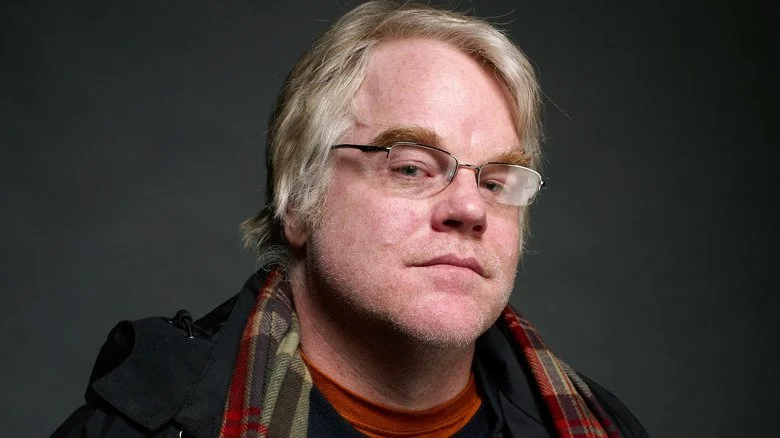 Philip Seymour Hoffman portant une écharpe et regardant la caméra de biais