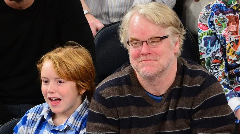 Philip Seymour Hoffman et Cooper Hoffman assis lors d'un match de basketball